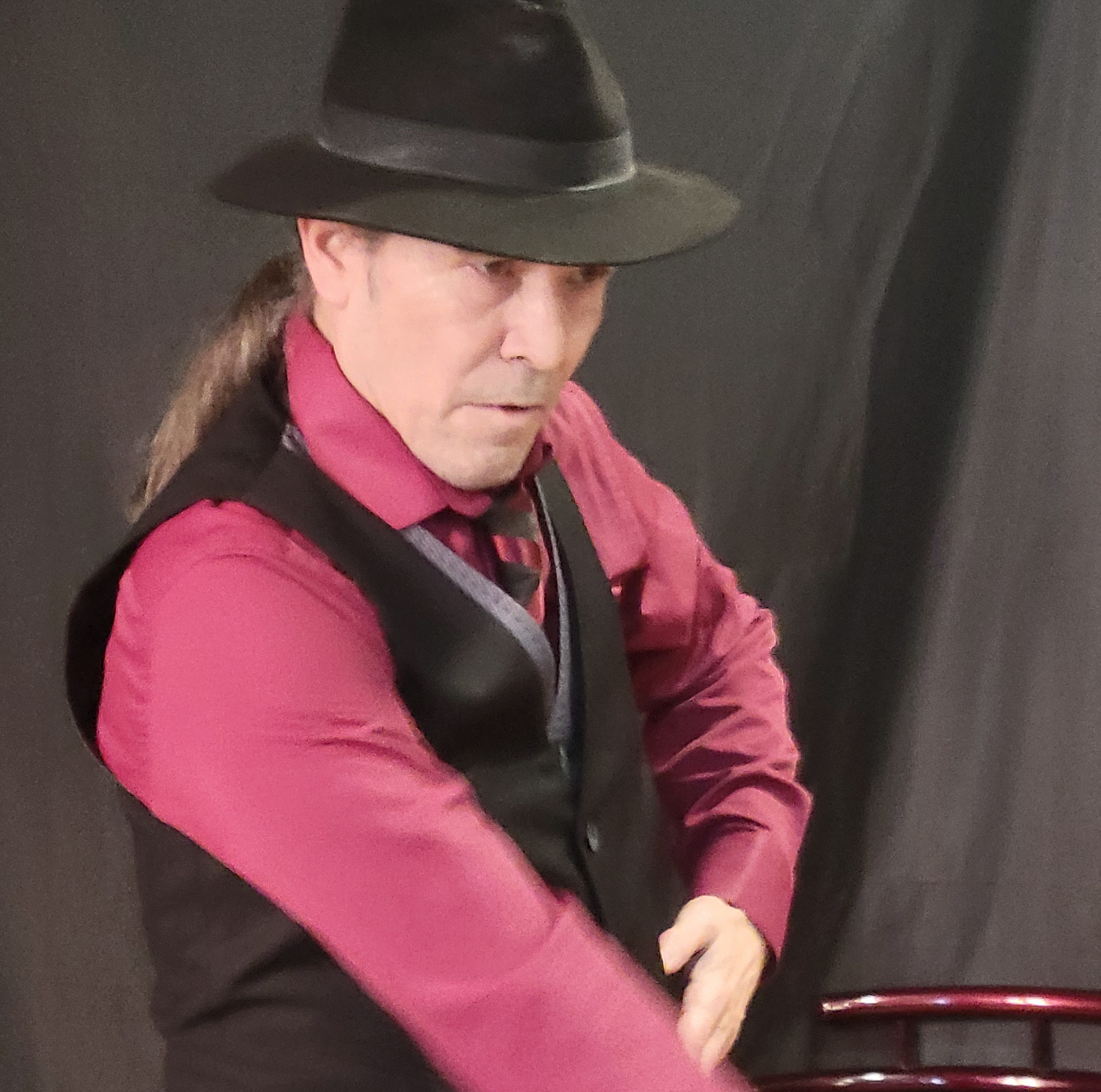 Antonio en tenue de scène, chapeau noir et chemise grenat, de profil