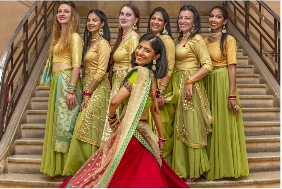 Danseuses en costumes indiens colorés devant un mur de pierre
