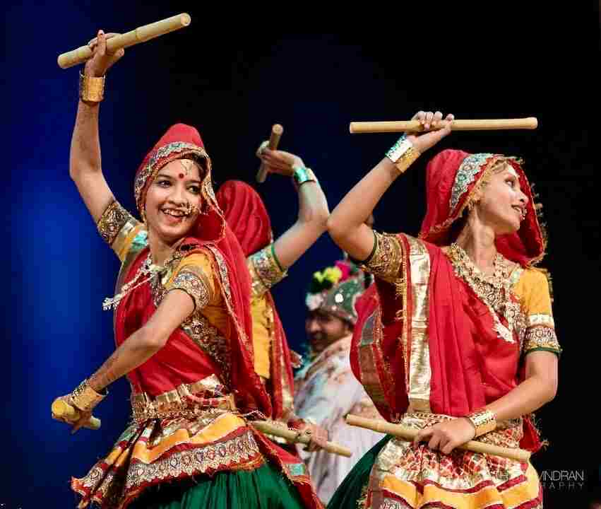 Deux danseuses de dandiya frappant leurs bâtons au-dessus de la tête
