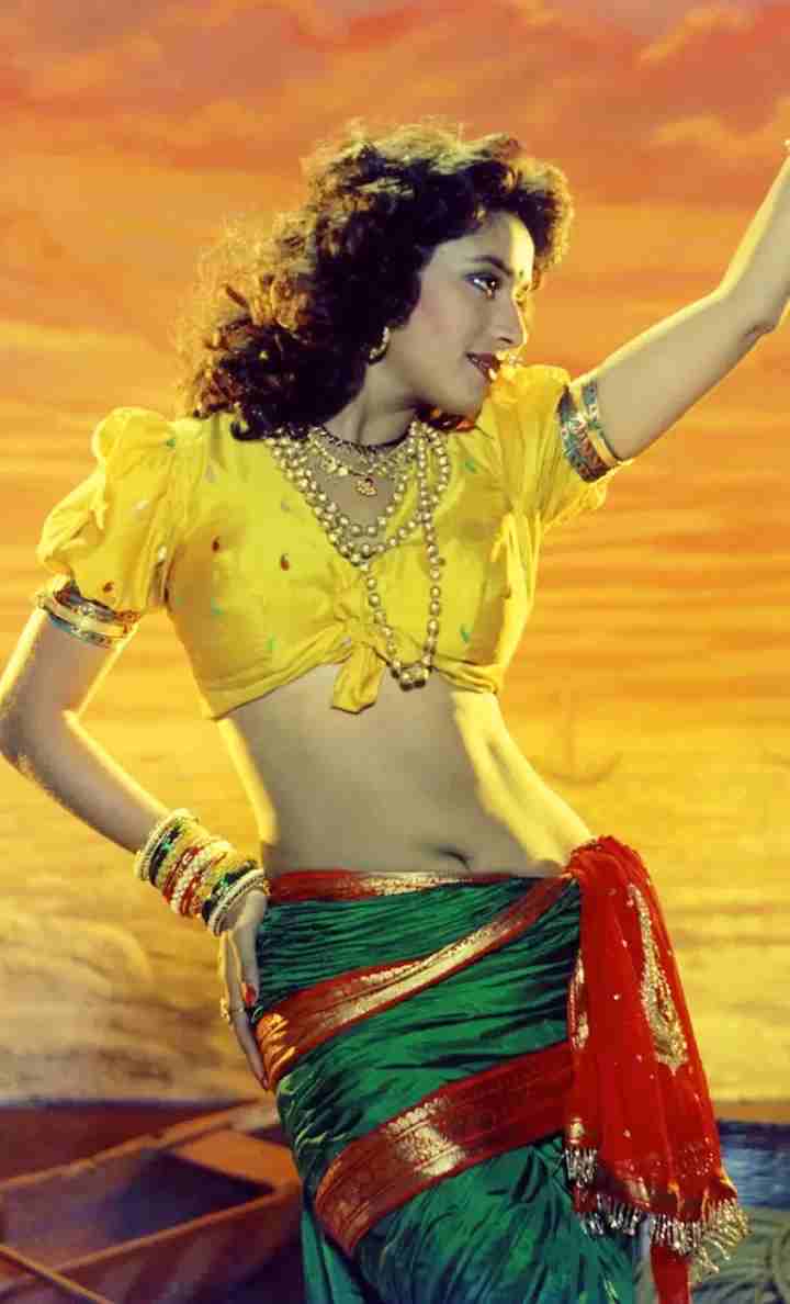 Danseuse de lavani en corsage jaune et sari drapé, bras tendu