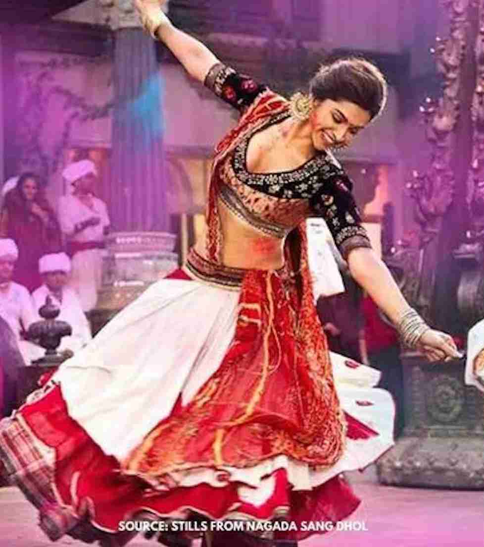 Danseuse en costume rouge et blanc, jupe déployée dans un mouvement de rotation