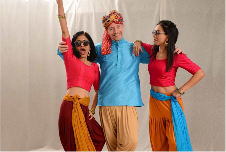 Deux danseuses et un danseur en costumes indiens colorés, posant ensemble