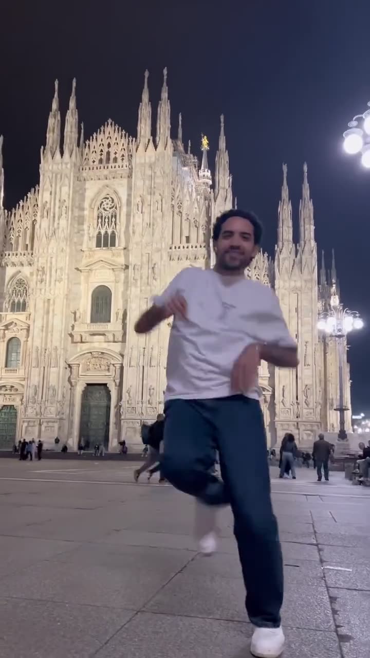 Elyes danse de nuit sur la place de la cathédrale de Milan, éclairée