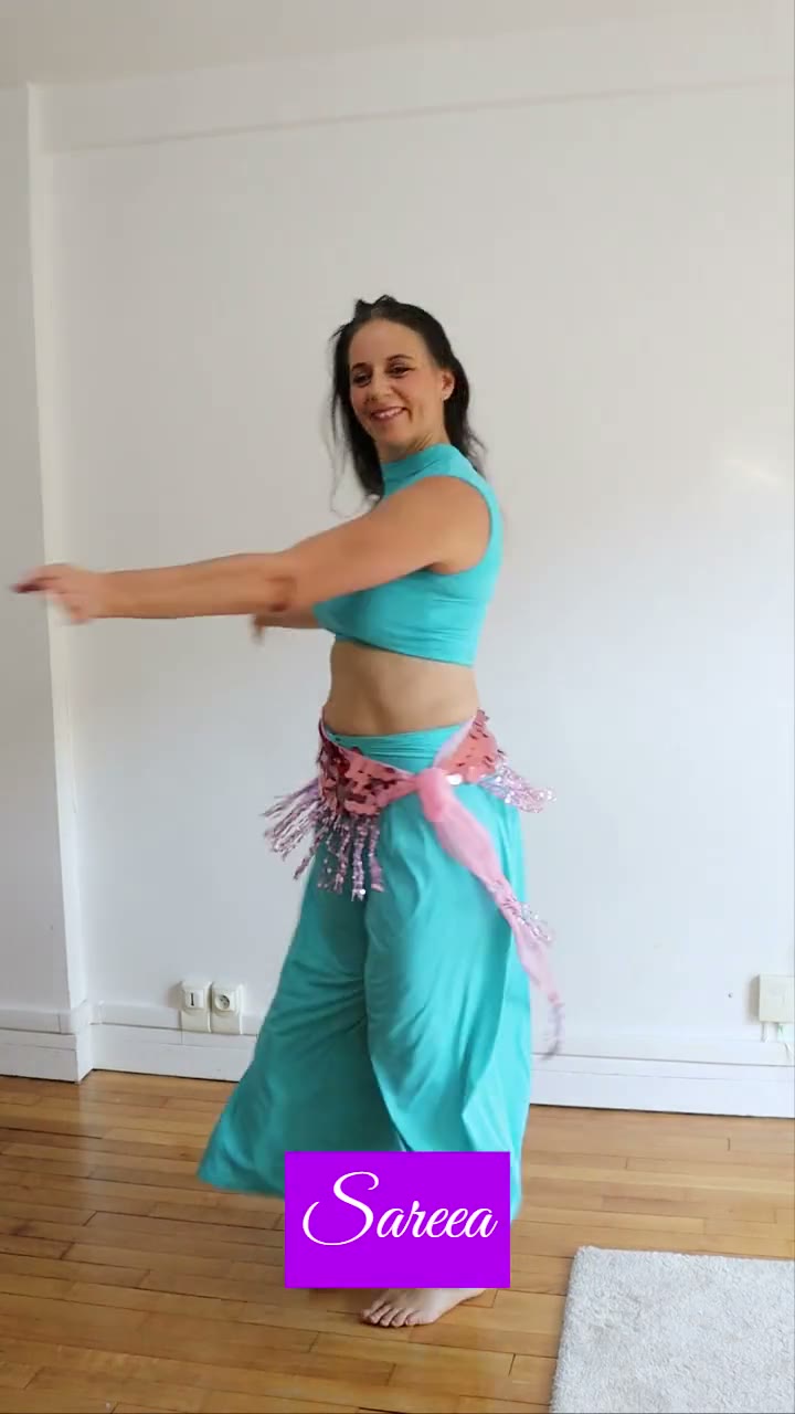 Sareea de face, bras tendus sur le côté, dans la même tenue turquoise
